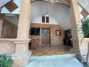 A spacious living area with a tiled floor, a wooden door, and a hanging light fixture. - Viewdoi Art and Resort (Chiang Mai)