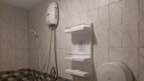 A bathroom with a shower, a toilet, and a hand dryer. - The 9 Resort (Bangkok)