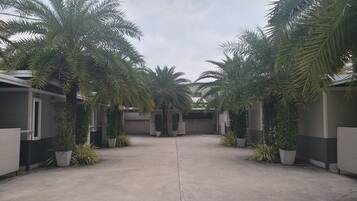 A courtyard with palm trees, a concrete floor, and a building with a number '403' on it.