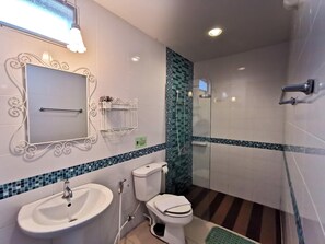A bathroom with a white sink, toilet, and shower area. - Baan Rabiang Talay (Hua Hin)