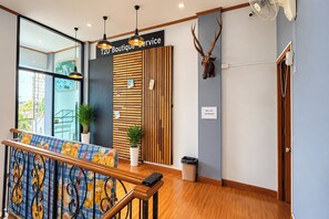 Una zona de recepción con un mostrador de madera, una cabeza de ciervo montada en la pared y un cartel que dice 'T2D Boutique Service'.