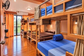 A bunk bed room with a wooden floor, a desk, a chair, and a window with curtains. - T2B Hostel (Chiang Mai)