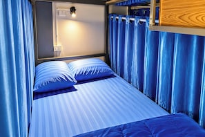 A bunk bed with two pillows and a headboard with a light fixture. - T2B Hostel (Chiang Mai)