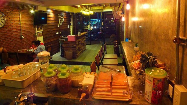 A restaurant interior with wooden walls, a bar area, and a seating section. - T2B Home - Hostel (Chiang Mai)