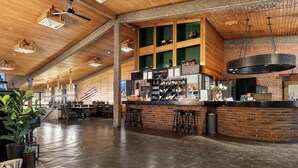 A spacious bar area with a brick counter, stools, and a hanging industrial-style light fixture. - Spåtind Fjellhotell (Nordre Land)