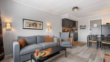 Una sala de estar moderna con un sofá gris, una mesa de centro y un comedor con sillas y una mesa.