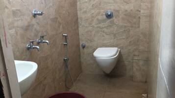Un baño pequeño con lavamanos, inodoro y ducha.