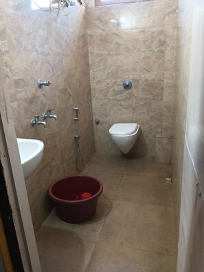 A small bathroom with a sink, toilet, and shower. - Hotel Prince (Guwahati)