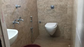 A small bathroom with a sink, toilet, and shower.