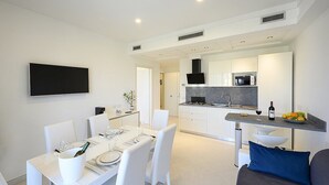 A modern kitchen with white cabinetry, a built-in microwave, and a gas stove.