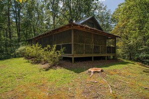 A cabin with a large screened porch, surrounded by a forest. - Horseshoe Hollow, Private Log Cabin on 10 acres (Lake Toxaway)