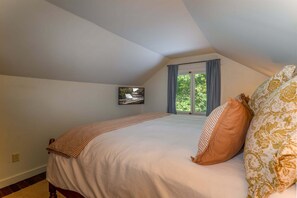 A bedroom with a bed, a window with curtains, and a wall-mounted picture. - Horseshoe Hollow, Private Log Cabin on 10 acres (Lake Toxaway)