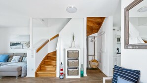 Ein modernes Wohnzimmer mit Treppe, Kamin und Küchenbereich.