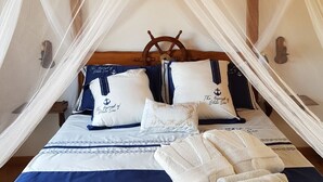 A bed with a nautical theme, including a ship's wheel headboard, navy and white bedding, and a canopy. - Petra manna summer Palau Sardinia  (PALAU)