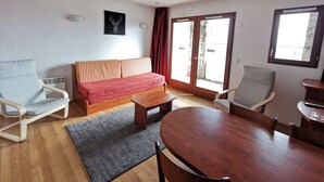 A living room with a sofa, two chairs, a coffee table, and a dining table. - Studio cabin - 4 guests, calm close to slopes (La Mongie)