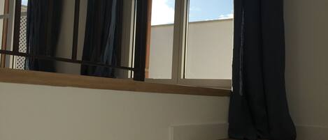 A staircase with wooden steps and a window with curtains.