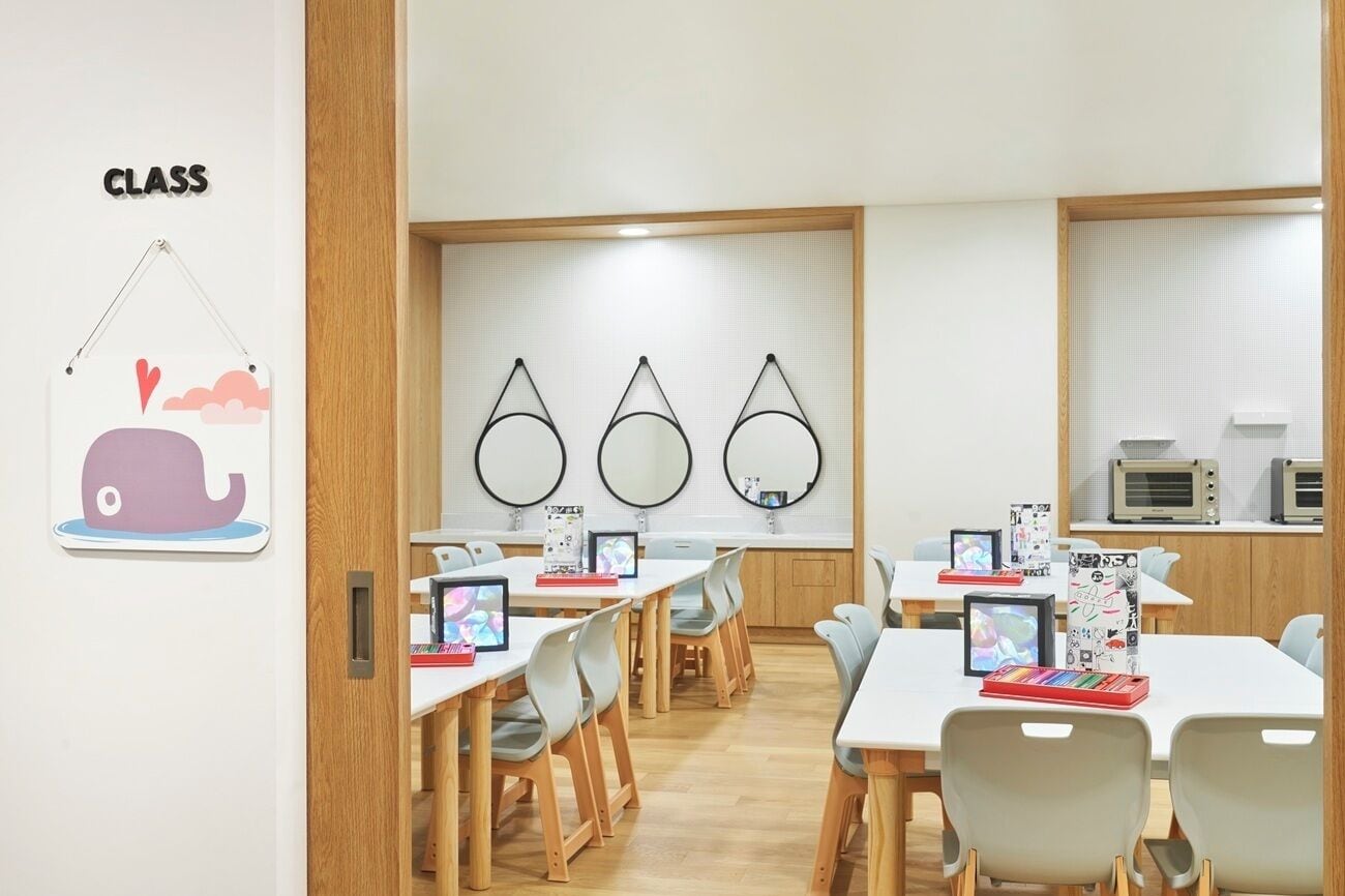 A classroom with tables, chairs, and educational materials.