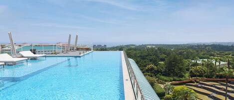 A large outdoor swimming pool with lounge chairs and a view of the surrounding landscape.