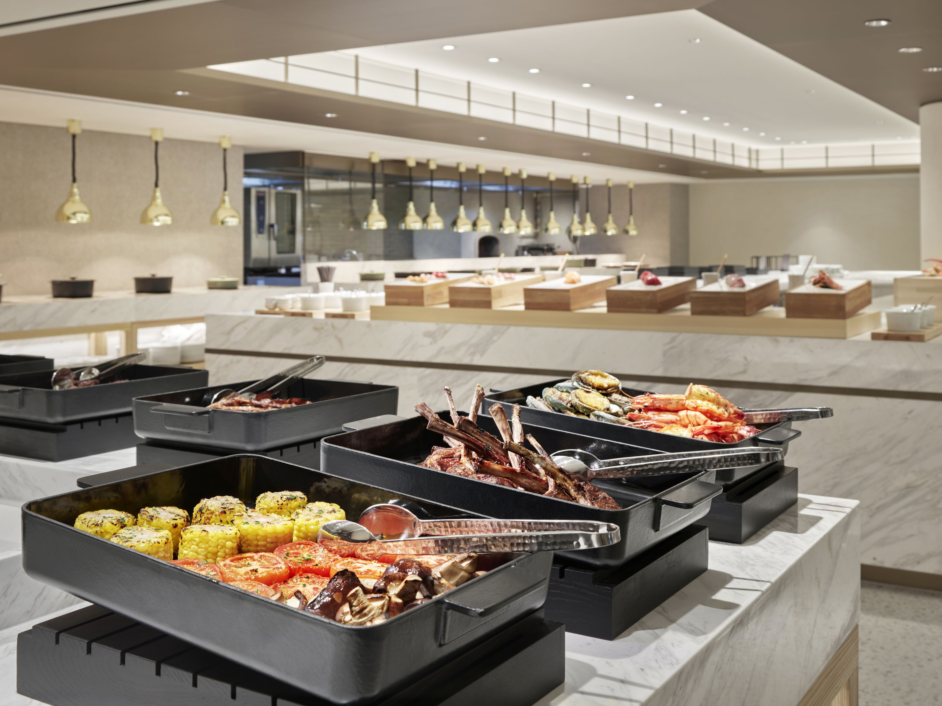 Un buffet proposant une variété de plats, notamment des viandes grillées, des fruits de mer et des légumes.