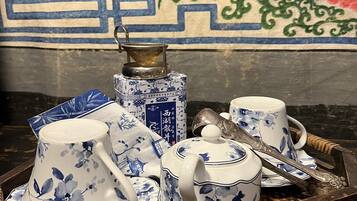 A tray with traditional blue and white porcelain tea set, including cups, saucers, and a teapot, placed on a wooden surface.