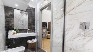 A modern bathroom with a bathtub, a sink, and a shower area. - Elys Suites (Sorrento)