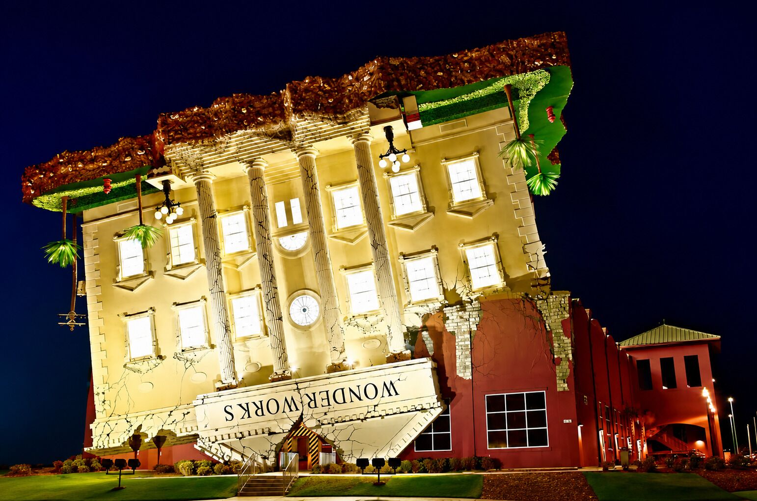 A building with a large sign reading 'MONDROUS' at the entrance, multiple windows, and a staircase leading up to the main entrance.