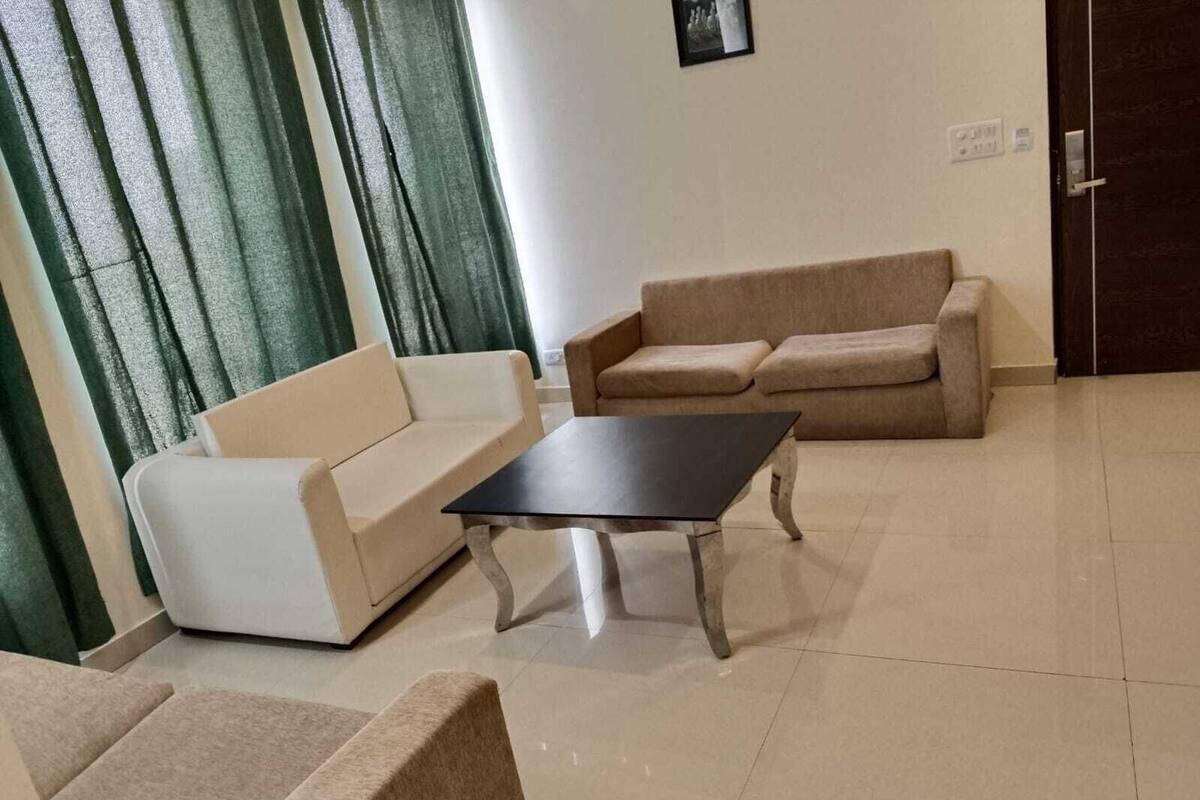 A living room with a white sofa, a beige sofa, and a black coffee table.