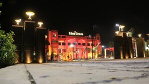 A hotel named Eden Green at night, with illuminated entrance and surrounding street lamps. - Eden Green (Ganaur)