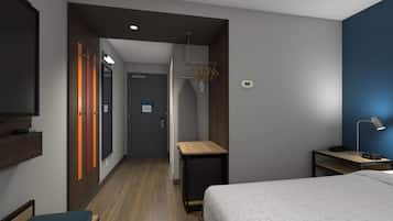 Een hotelkamer met een bed, bureau, televisie en een badkamer met douche en toilet.