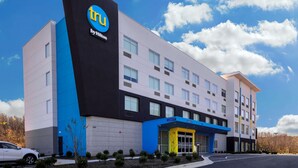 Un moderno edificio de hotel con un llamativo logotipo 'tu', varios pisos y una zona de entrada azul.