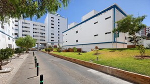 A street with a sidewalk, a building with a blue trim, and a no parking sign. - Holiday Apartment “Da Praia” with Air Conditioning, Balcony, Shared Garden & WiFi (Portimão)