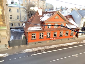 A red building with the sign "Alkimikis" and a sign indicating "Restorans." - Brivibas City Center Two bedroom Apartment (Rīga)