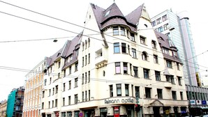 A multi-story building with a distinctive architectural style, featuring a curved facade and multiple windows.