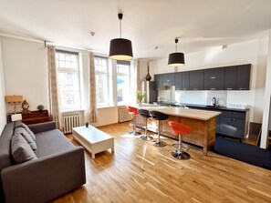 Eine moderne Wohnung mit Wohnbereich, Küche und Essbereich.