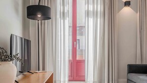 A modern living room with a wooden console table, a floor lamp, a grey rug, and a grey sofa. - Uma Formosa Apartments (Porto)