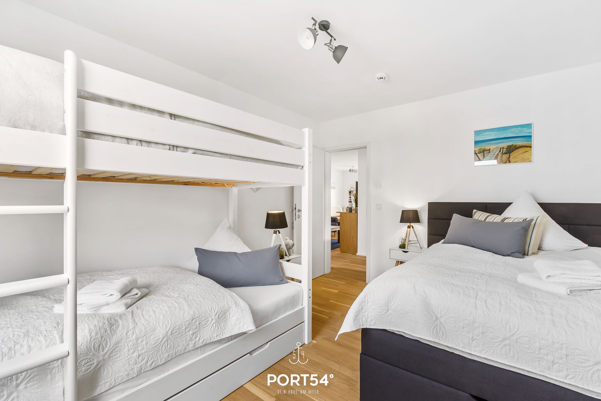 Ein Hotelzimmer mit Etagenbetten, einem Schreibtisch und einem Bild an der Wand.