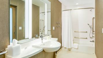 Un baño moderno con dos lavamanos, un espejo grande, una zona de ducha con puerta de cristal y una bañera.