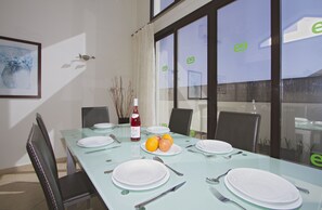 Enjoy meals with friends and family at this dining area, featuring a glass table and six comfortable chairs.