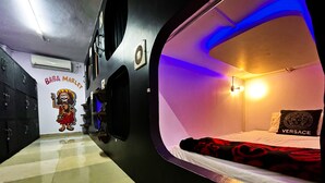 A room with a bed, a wall-mounted TV, and a poster of 'Baba Marley'. - Mad Squad Hostel (Varanasi)