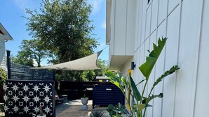 A modern house with a gravel pathway, potted plants, and a decorative fence. - Pet friendly studio apartment. Minimal shedding dogs only.1 dog max.$25 pet fee (Kill Devil Hills)