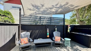 An outdoor patio with two wooden chairs, a small table, and a canopy. - Pet friendly studio apartment. Minimal shedding dogs only.1 dog max.$25 pet fee (Kill Devil Hills)