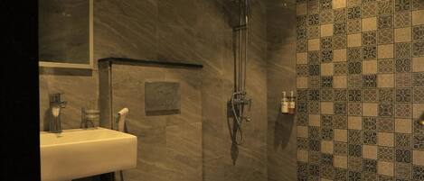A modern bathroom with a shower, toilet, and sink.