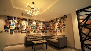 Una habitación acogedora con un conjunto de sofá, una mesita de centro y una pared decorada con numerosas fotografías enmarcadas.
