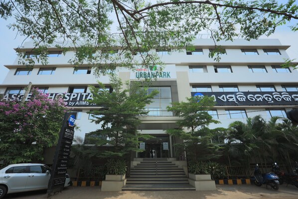 Un edificio de varios pisos con un cartel que dice 'URBAN PARK' y 'ASG HOSPITAL by AIIMS'.