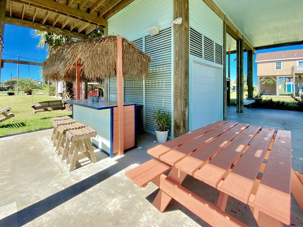 Un patio al aire libre con bancos de madera y una estructura de techo de paja.