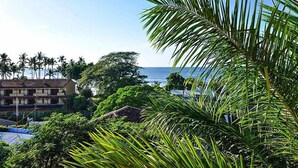 A coastal hotel with a view of the ocean, surrounded by lush greenery and palm trees. - Stay in Tamarindo Condominiums (Tamarindo)