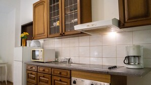A kitchen with wooden cabinets, a microwave, a coffee maker, and a stove. - Beautiful 2BR - 12 min from Downtown (Vienna)