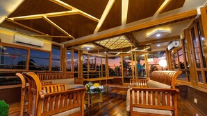 Un interior acogedor con muebles de madera, ventanas amplias y un techo con patrones geométricos.