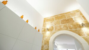 A modern interior with a stone wall and a white tiled floor. - CITY HOUSE SA FONT IN SANTA CATALINA (Palma)
