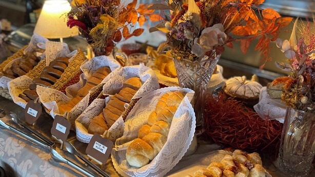 Een buffet met diverse gebakjes en decoratieve bloemstukken.